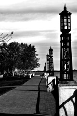 Black and white photo of light posts along the Chesapeake Bay, including a walking path and trees...