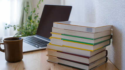 机上の本とノートパソコン