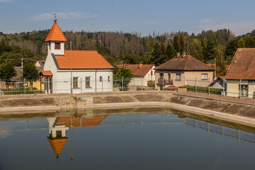 Fototapeta na wymiar Trinity chapel and a water tank in Libez village, Czech Republic