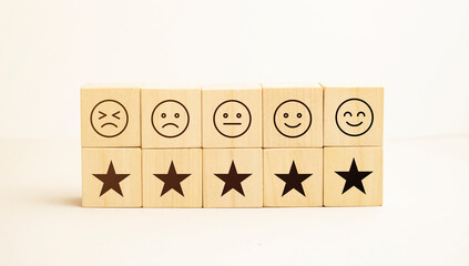 emotion face and Star symbol blocks on table background. Service rating, ranking, customer review, satisfaction, evaluation and feedback concept