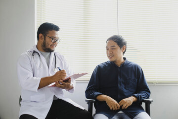 Obraz premium Cheerful doctor and patient while taking patient's medical record