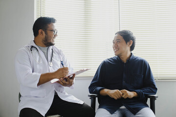 Obraz premium Cheerful doctor and patient while taking patient's medical record