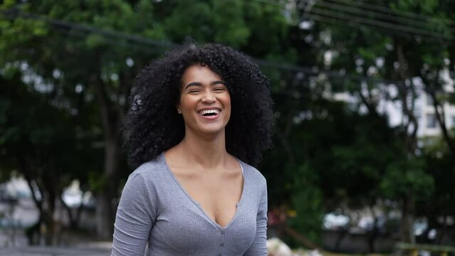 A happy Brazilian woman standing outside in urban street