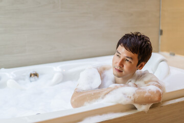 man washing body with foam in bathtub