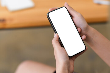 Close-up image, focus female hands holding a mockup screen of mobile phone