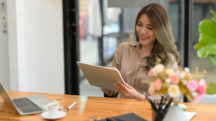 Obraz premium Young entrepreneur woman using her digital tablet.