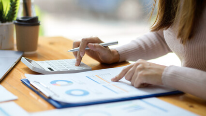 A female accountant using calculator to calculate her business expenses.