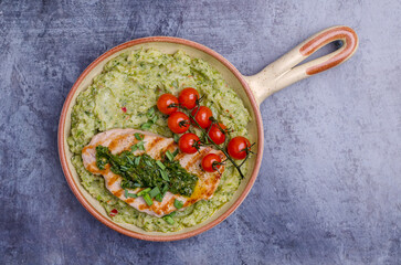 Grilled steak with green mashed potatoes and tomatoes
