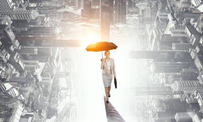 Businesswoman running with umbrella . Mixed media