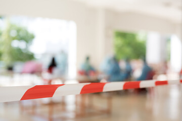 Row of empty red chairs and warning tape infection area.No entry sign concept.Selective focus.