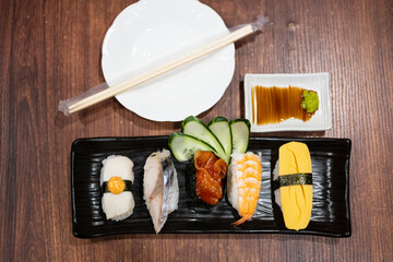 Top view japanese sushi food.Sushi roll menu in black plate on wood table background. Japanese food.