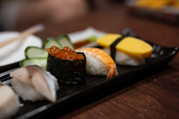 Close up japanese sushi food.Sushi roll menu in black plate on wood table background. Japanese food.