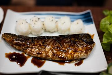 Close up mackerel fish sliced and grilled for sushi menu.A set of sushi on a wooden table in a Japanese restaurant.Party of friends or family eating sushi using bamboo sticks.