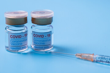 Close-up of COVID-19 coronavirus vaccine. Glass bottle with injection solution and syringe. Copy space