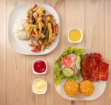Peruvian dishes, lomo saltado and cecina with tacacho. Pork, beaf, potato and rice. Photo above	