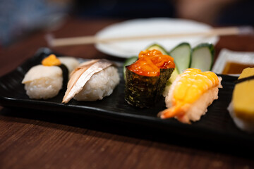 Close up japanese sushi food.Sushi roll menu in black plate on wood table background. Japanese food.