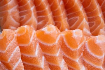 close up salmon fillet slices texture.Row salmon fish sliced on plate at Japanese restaurant.