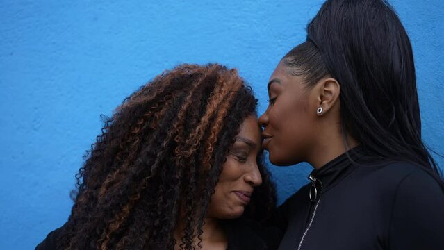 Daughter kissing mother in forehead