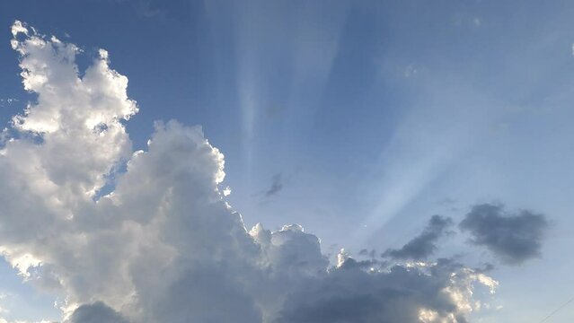 Dramatic rain clouds n sun light ray or sunbeam on blue sky