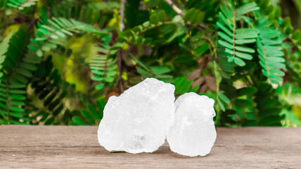 Crystal clear alum cubes or Potassium alum on brown wood plank. Chemical compound substance....