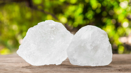 Crystal clear alum cubes or Potassium alum on brown wood plank. Chemical compound substance. Concept for beauty , spa and underarm treatment industrial. 