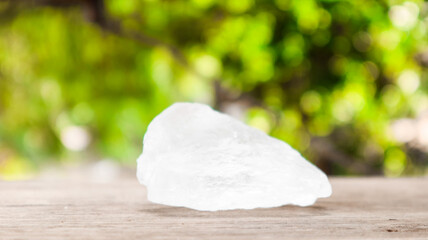 Crystal clear alum cubes or Potassium alum on brown wood plank. Chemical compound substance. Concept for beauty , spa and underarm treatment industrial. 