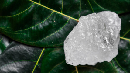 Crystal clear alum cubes or Potassium alum on green leaf. Chemical compound substance. Concept for...