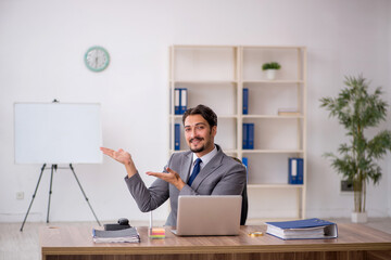 Young male employee sitting in the office