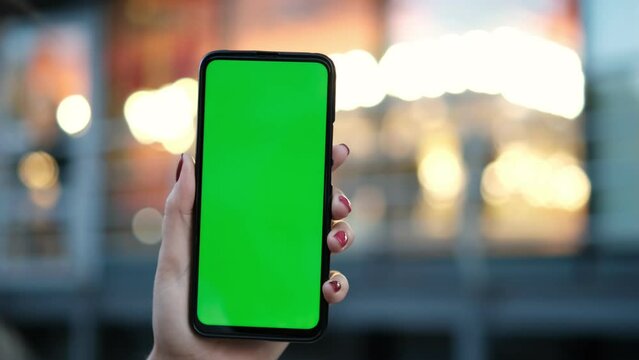 Point of View of voman at street Using Phone With Green Mock-up Screen Chroma Key Surfing Internet Watching Content Videos Blogs Tapping on Center Screen