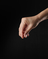 Hand holding pink salt on black background