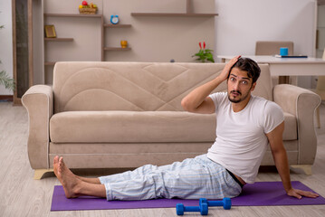 Young man doing sport exercises at home