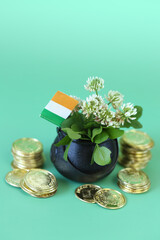  Saint Patrick holiday. Ireland flag , black bowler hat with gold coins, bunch of clovers 