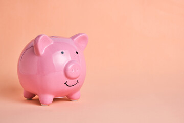 Pink piggy bank on pastel beige background.Concept saving and accumulating money.