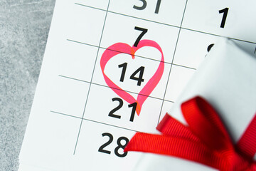 Close up calendar with 14 February date Valentines day with red heart shape marker and gift box