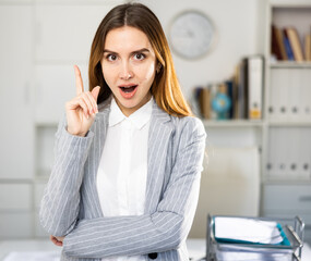 Closeup portrait of positive business lady having creative idea, standing in modern office