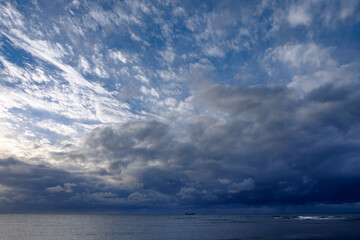 海の地平線と朝日に照らされる雲