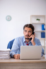 Young male employee and too much work in the office