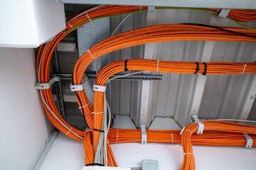 orange network cables run bundled under the ceiling
