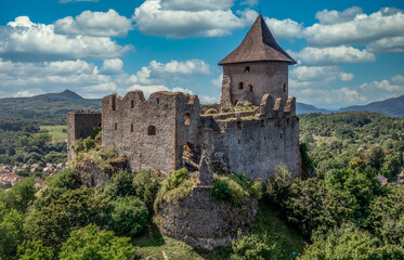 Fototapeta na wymiar Aerial view of Somosko medieval castle between Slovakia and Hungary on a hilltop with triangle shape and three round towers, one cowered with a roof