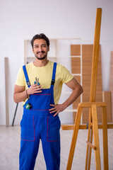 Young male repairman repairing easel at home