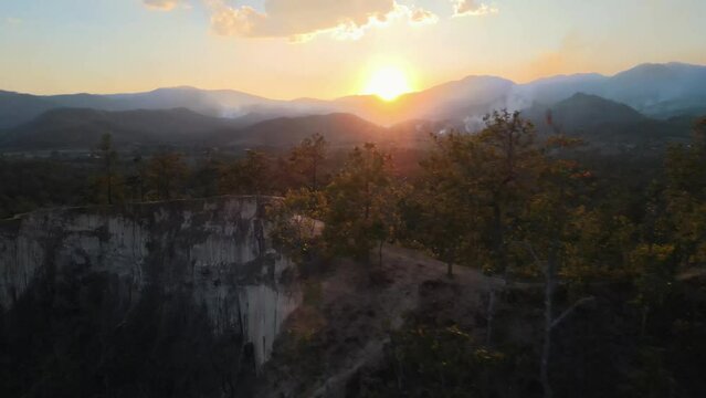 Beautiful Pai Canyon which is known for the beautiful hiking trails along the steep mountain walls during the sunset that rises just above the silhouettes of the mountains. Drone panning shot