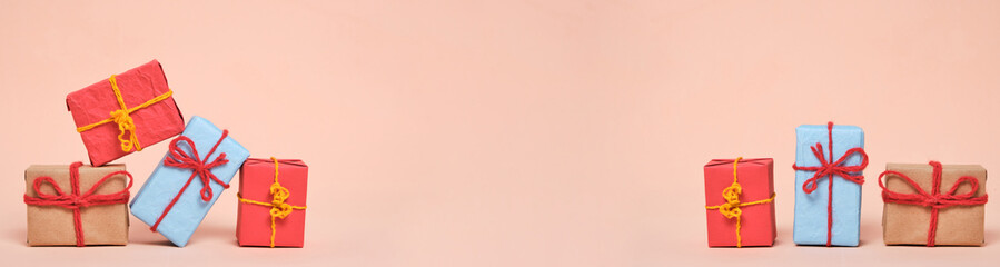Banner, gifts packed in multicolored paper on pastel beige background.Concept Christmas holidays and eighth March in spring.