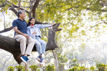 Happy father and daughter having fun blowing bubbles at park.