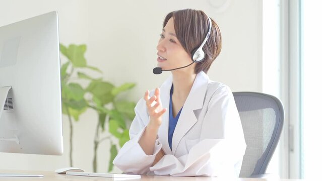 ヘッドセットをつけて話す白衣を着た女性