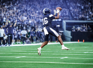 American Football Player catching a pass during a game. Composite photo