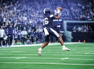 Rolgordijnen zonder boren American Football Player catching a pass during a game. Composite photo © Brocreative
