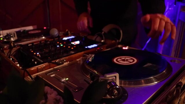 DJ scratching his turn tables at a luxury event.