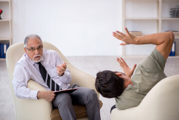 Fototapeta premium Young man visiting old psychologist