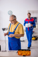 Two male repairmen working at workshop