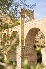 Old arched stone bridge in sunlight. Alcantara Bridge.